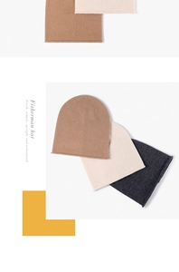 Close-up of fine knit merino wool fisherman hats in camel, beige, and dark grey tones