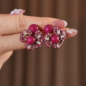 Macro shot of vintage floral earrings with purple enamel and pavé rhinestones