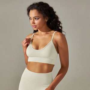 Detail of seamless ribbed hem and V-neckline on a cream-white knit yoga sports bra