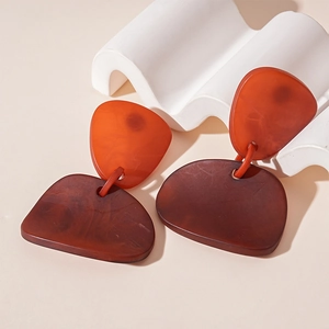 Détail de boucles d'oreilles géométriques en acrylique avec texture écaille de tortue