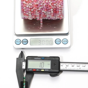 Detailed macro view of 1.0mm pink gradient amethyst beads chain on electronic scale and caliper