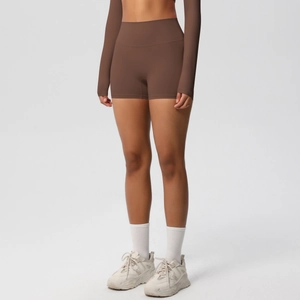 Detail of high-waist dark brown yoga shorts and long sleeve crop top in matte finish