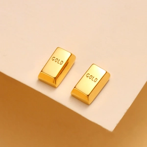 Detailed close-up of 18K gold-plated bar stud earrings featuring engraved GOLD lettering