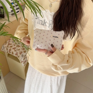 Floral quilted mini pouch held in hand, perfect for travel makeup and small cards
