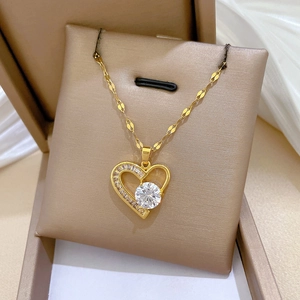 Detail shot of heart-shaped gold-plated necklace with clear stones in gift box