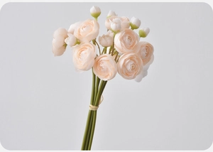 Detailed view of artificial ranunculus bridal bouquet in soft cream and light pink tones