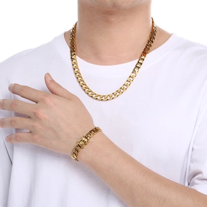 Close-up of a men's chunky gold Cuban link necklace and matching bracelet set