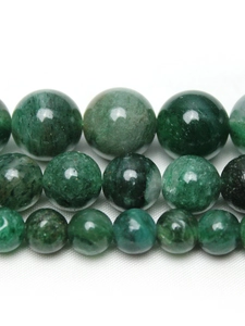 Macro shot of green mica round beads in three sizes with natural polished texture