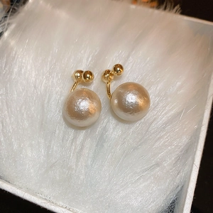 Boucles d'oreilles vintage en perles plaquées or sur fond de fausse fourrure blanche