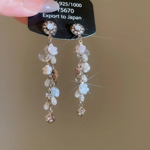 Dettaglio degli orecchini pendenti in argento 925 con petali di resina e nappa lunga