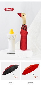 Detail of creative duck head wood handle on a red three-fold sun and rain umbrella