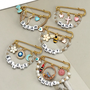 Set of five gold evil eye brooches featuring Dream, Mama, Happy, Believe, and Angel beads