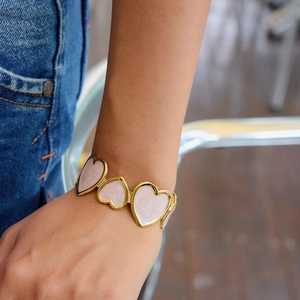 Close-up of 18K gold stainless steel bracelet featuring pink marble heart-shaped links