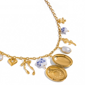 Close-up van vintage medaillon met keramische kralen en parels aan een gouden ketting