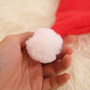 Red non-woven Christmas hat with a soft white plush pom-pom detail on top