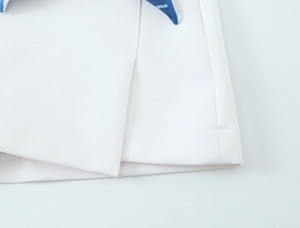 Detailed view of white asymmetrical layered hem and fine stitching on the stylish scarf skirt