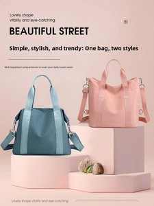 Detail view of large nylon tote bags in grey blue and peach pink with wide strap handles