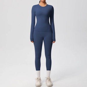 Dettaglio completo del set da yoga blu scuro con maglia a maniche lunghe e leggings a vita alta
