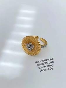 Macro detail of 18K gold plated ring with radial texture and sparkling white zircon stones