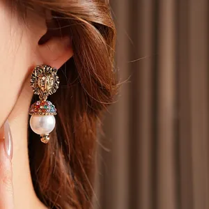 Vintage lion head pearl earrings with crystals for a luxurious gold-tone aesthetic