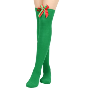 Detail of green knit over-knee Christmas socks with a red and green ribbon bow
