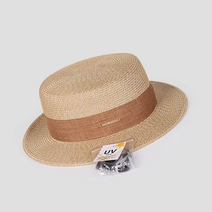 Détail d'un chapeau canotier avec ruban marron foncé et accessoire de protection contre les UV