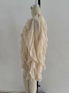 Detail of layered cascading ruffles on a cream chiffon blouse with light texture