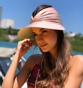 Detail of pink open top sun hat with wide brim and pleated texture for outdoor activities