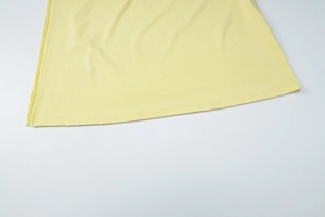 Detail shot of the pale yellow dress hem featuring durable double-needle stitching