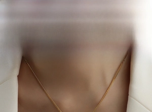 Close-up of elegant gold curb chain necklace with pearls worn on model neckline