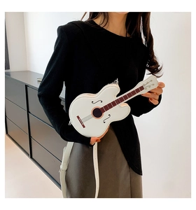 Detail view of a white violin-shaped crossbody bag with realistic strings and f-hole print