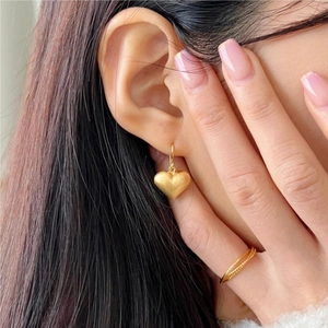 Close-up of a model wearing a brushed gold heart stud earring in 925 sterling silver