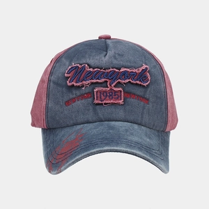 Detailed close-up of vintage washed grey and red baseball cap with New York 1985 embroidery