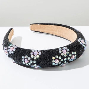 Close-up of sparkling heart and star rhinestones on thick black velvet headband