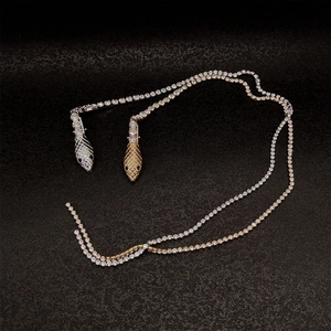 Elegant gold and silver snake necklaces with glittering diamonds on a dark background