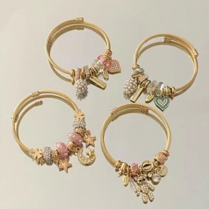 Detailed view of adjustable gold stainless steel cable bracelets with mixed charms