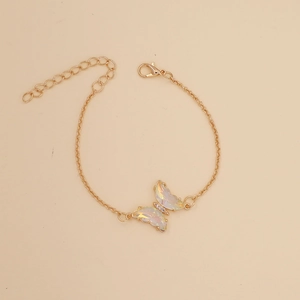 Macro shot of gold butterfly pendant necklace with iridescent crystal wings and clasp