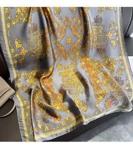 Detail of vintage grey silk shawl with elegant golden Baroque floral pattern and glossy texture