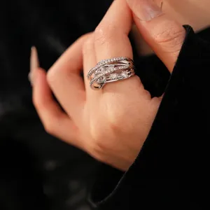 Multi-layer silver crisscross ring with cubic zirconia stones worn on finger