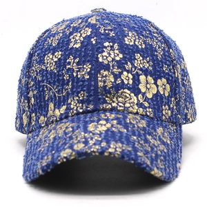 Detail of blue tweed baseball cap featuring vintage gold floral foil print and texture