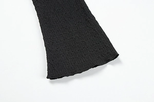 Détail d'une robe noire avec texture plissée et tissu à haute élasticité