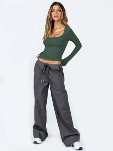 Détail du haut en tricot vert foncé à manches longues avec pantalon cargo gris