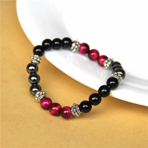 Close-up of tiger eye bead bracelet with silver spacers on white porcelain plate