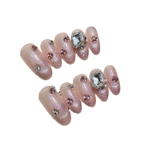 Handmade almond press-on nails in light pink glitter finish with large rectangle rhinestones
