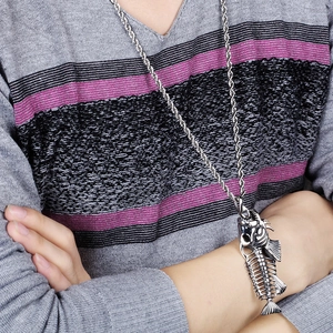 Close-up of vintage silver fish bone pendant necklace on a striped sweater