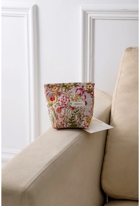 Macro detail of floral embroidery fabric and flower zipper pull on makeup bag