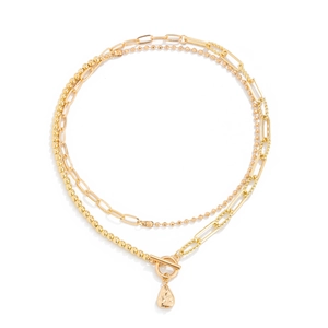 Close-up of golden multi-layer chain necklace with toggle clasp and teardrop pendant