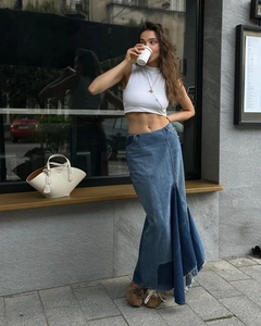 Detailed view of the frayed hemline and patchwork design on this high waist denim maxi skirt
