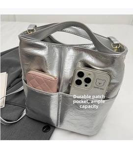 Silver metallic textured bucket bag with dual front pockets showing spacious inner capacity