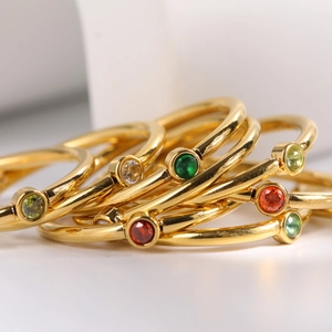 Gold plated stainless steel stackable rings featuring vibrant December birthstone charms
